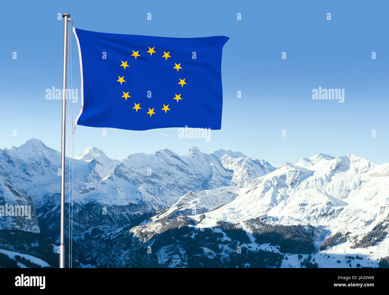 Composite with the flag of the European Union fluttering in the wind and snow capped mountains in the background. Stock Photo