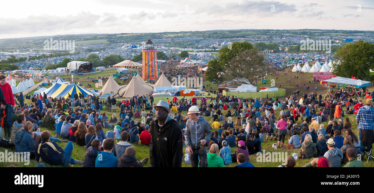 GLASTONBURY, UK -JUNE, 22: Panoramic view showing crowds of people on the hill overlooking the site of Glastonbury Festival on 22nd June 2011. The thr Stock Photo