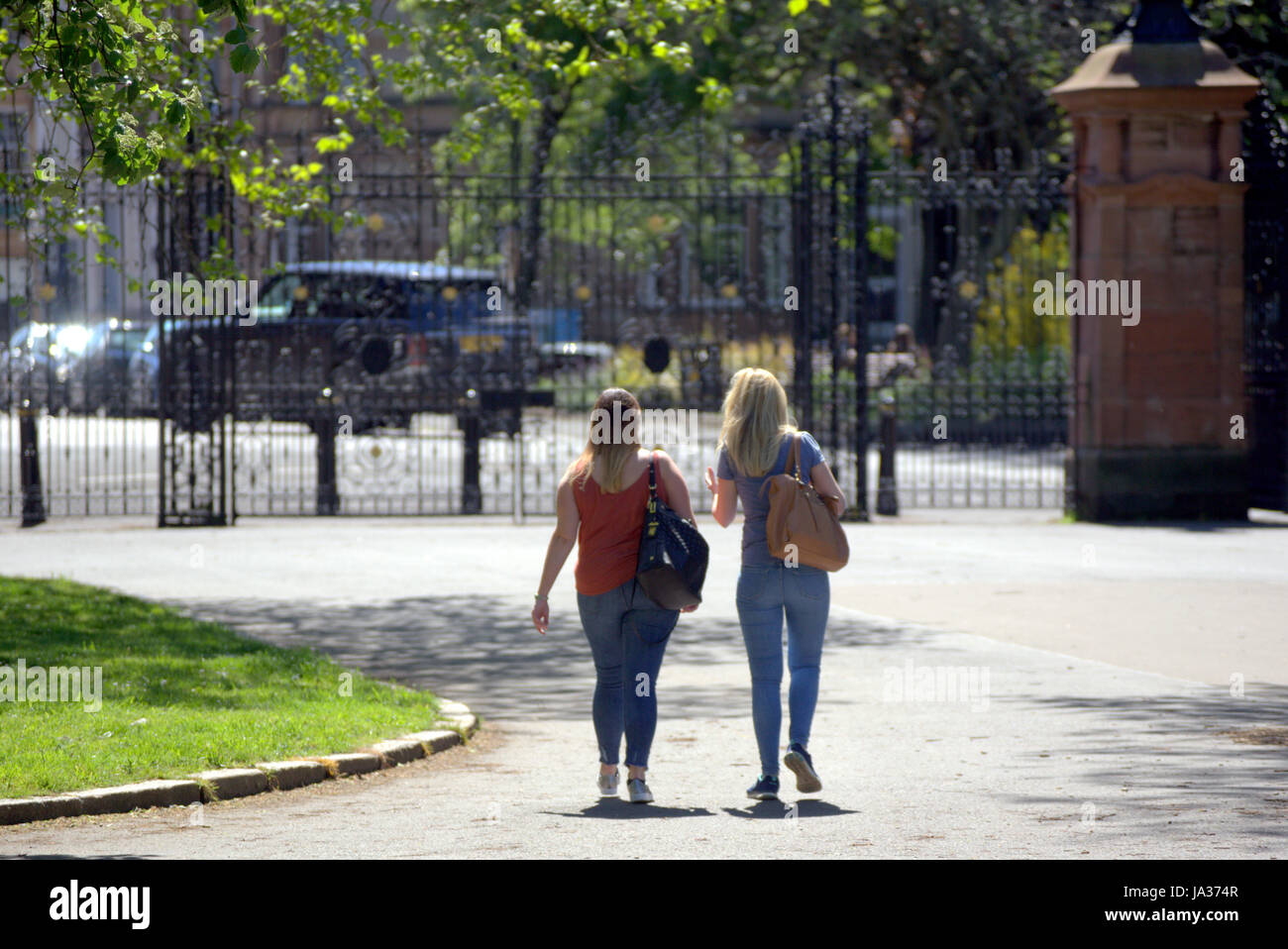 Glasgow Kelvingrove park scenes girls walking towards Victorian iron gates Stock Photo