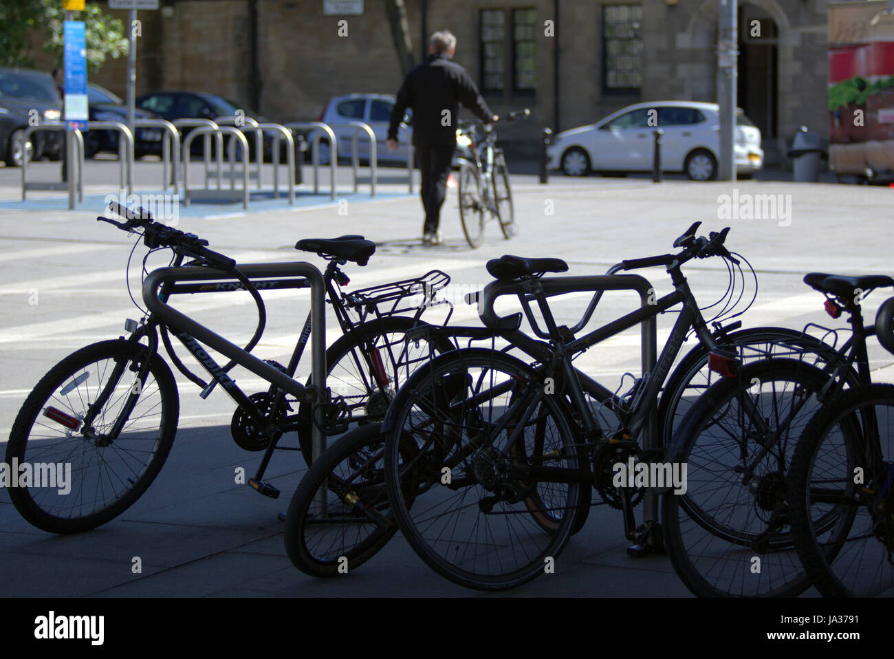 generic cyclist silhouette bike rack foreground  and solo biker background Stock Photo