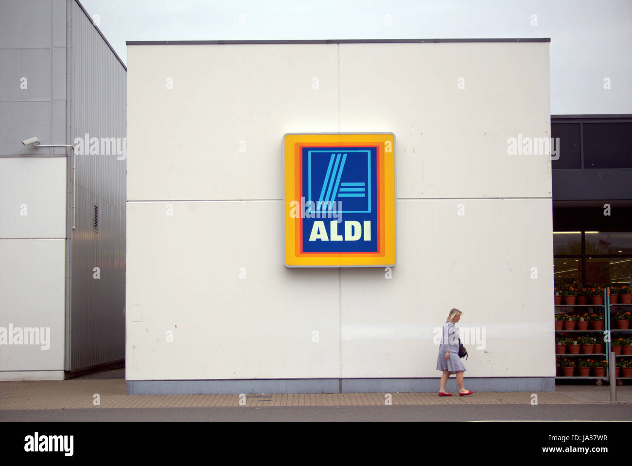 Aldi supermarket logo with customers walking by Stock Photo