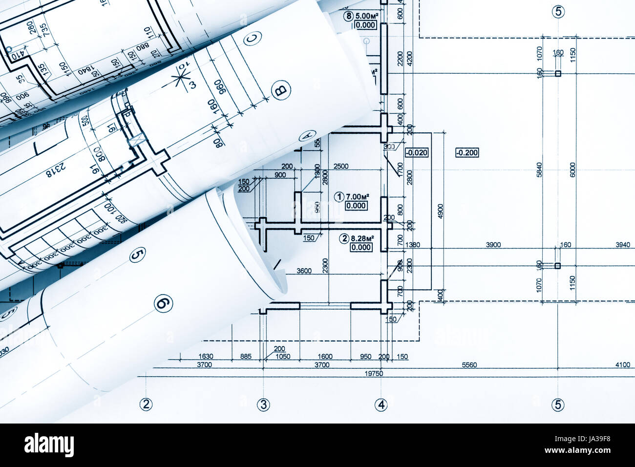 rolls of drawing paper with architectural project plans on blueprint background Stock Photo