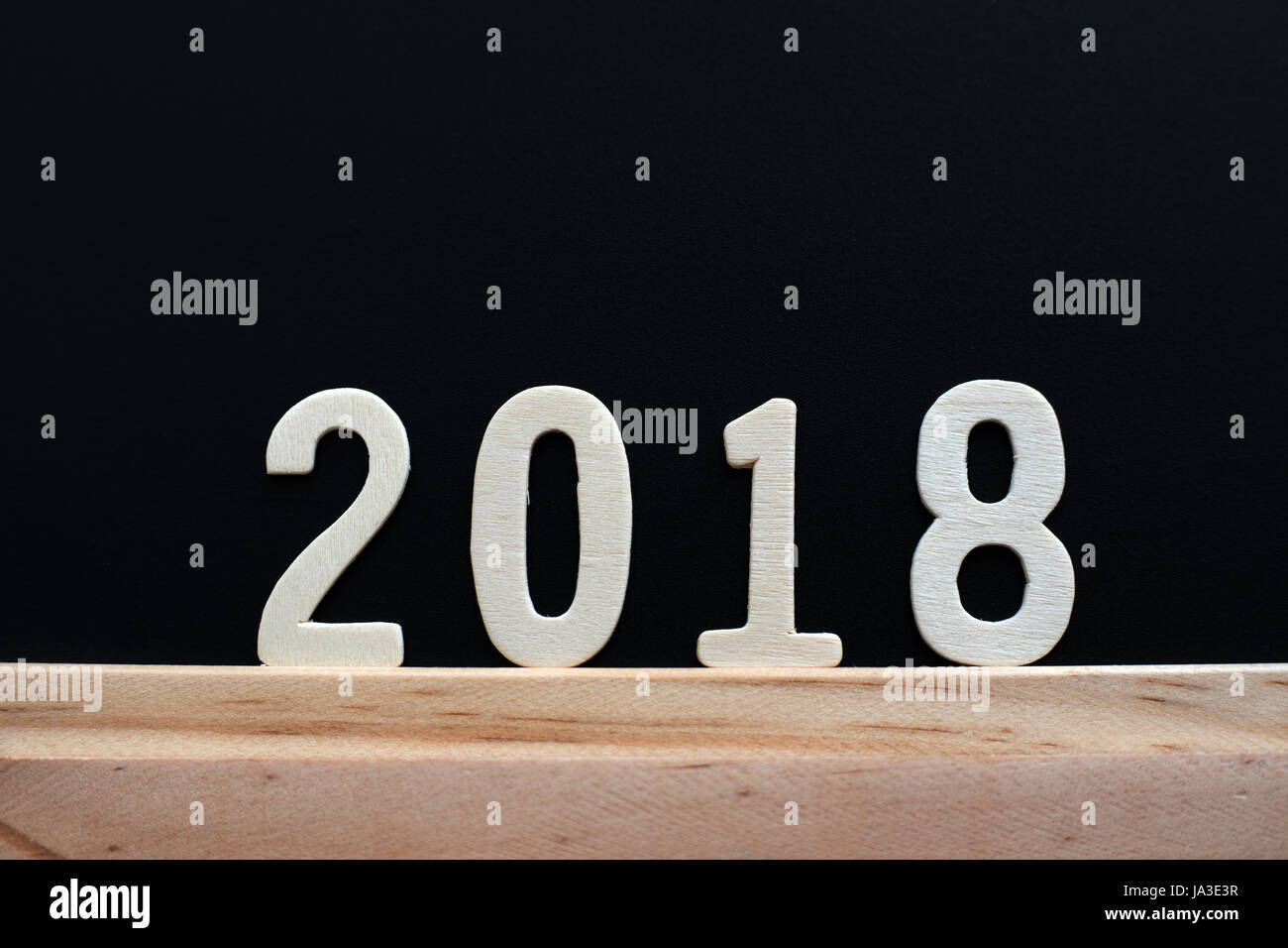 wood word of 2018 numbers lie on wooden table and black background ...