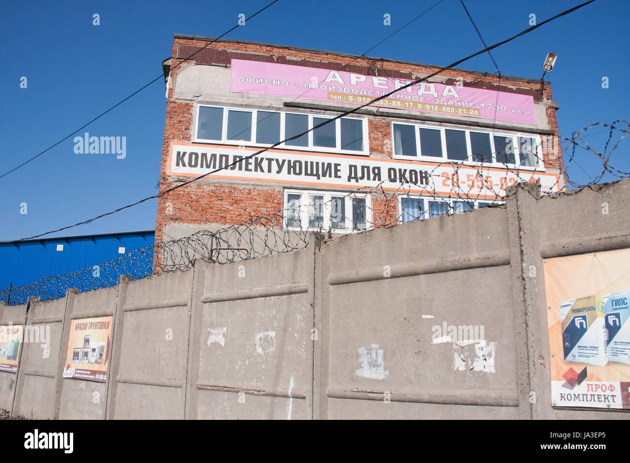 Perm, Russia - March 31.2016:  Building with billboards on trading base behind a fence Stock Photo