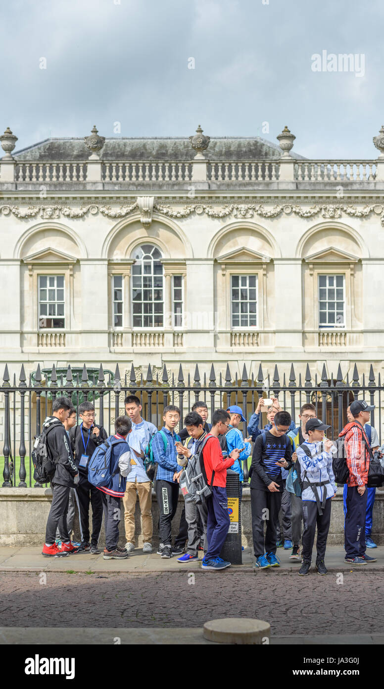 A group of young chinese students in front of the railings outside Senate House, university of Cambridge, England. Stock Photo