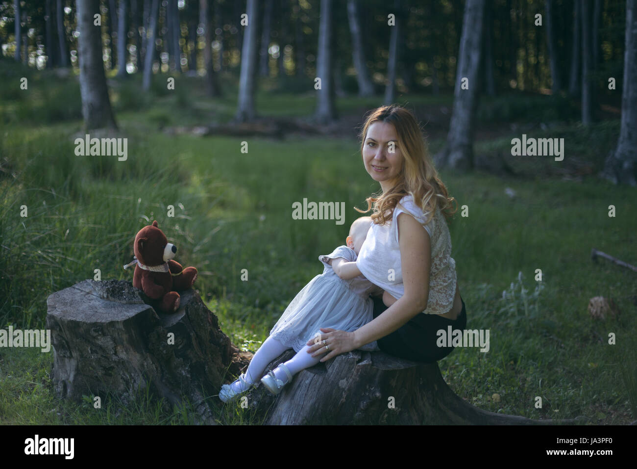 Mother breastfeeding baby girl outside in nature Stock Photo Alamy