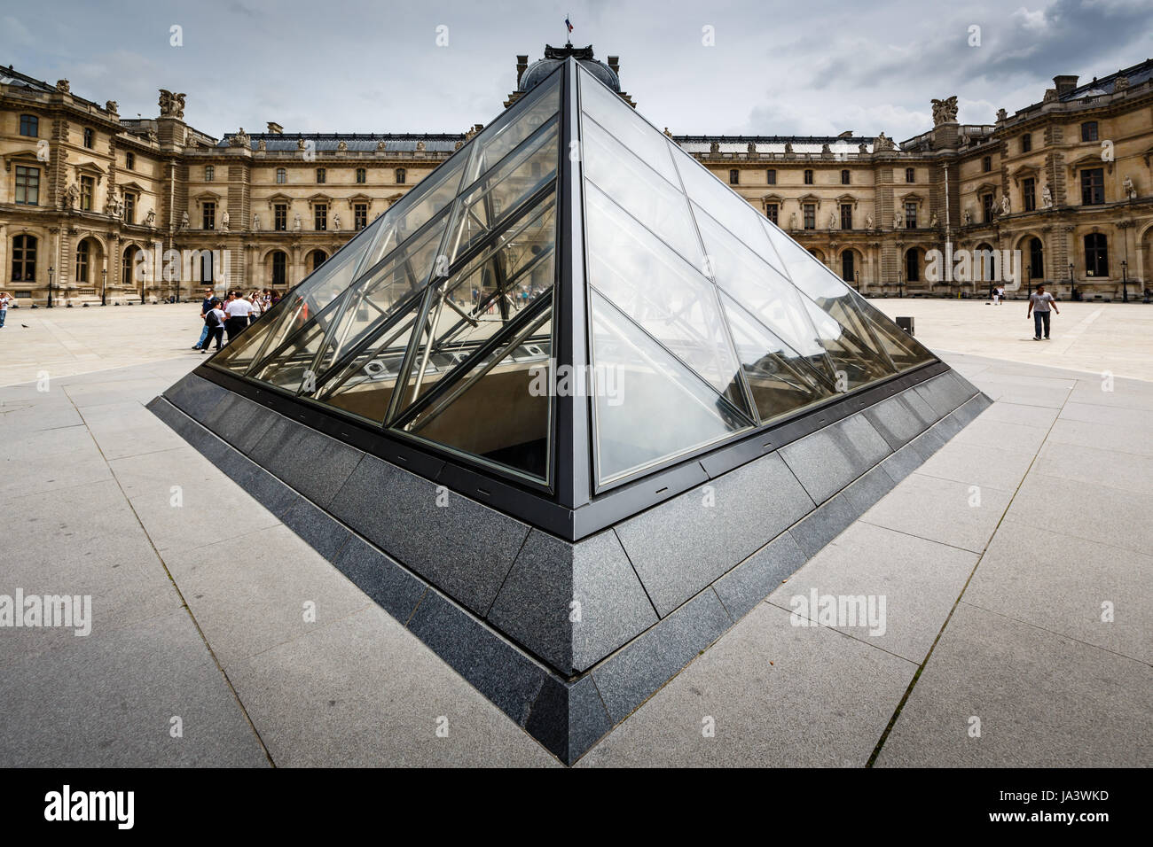 PARIS - JULY 1: Glass Pyramid in Front of the Louvre Museum on July 1, 2013. The Louvre is one of the world's largest museums in Paris. Nearly 35,000 objects are exhibited here. Stock Photo
