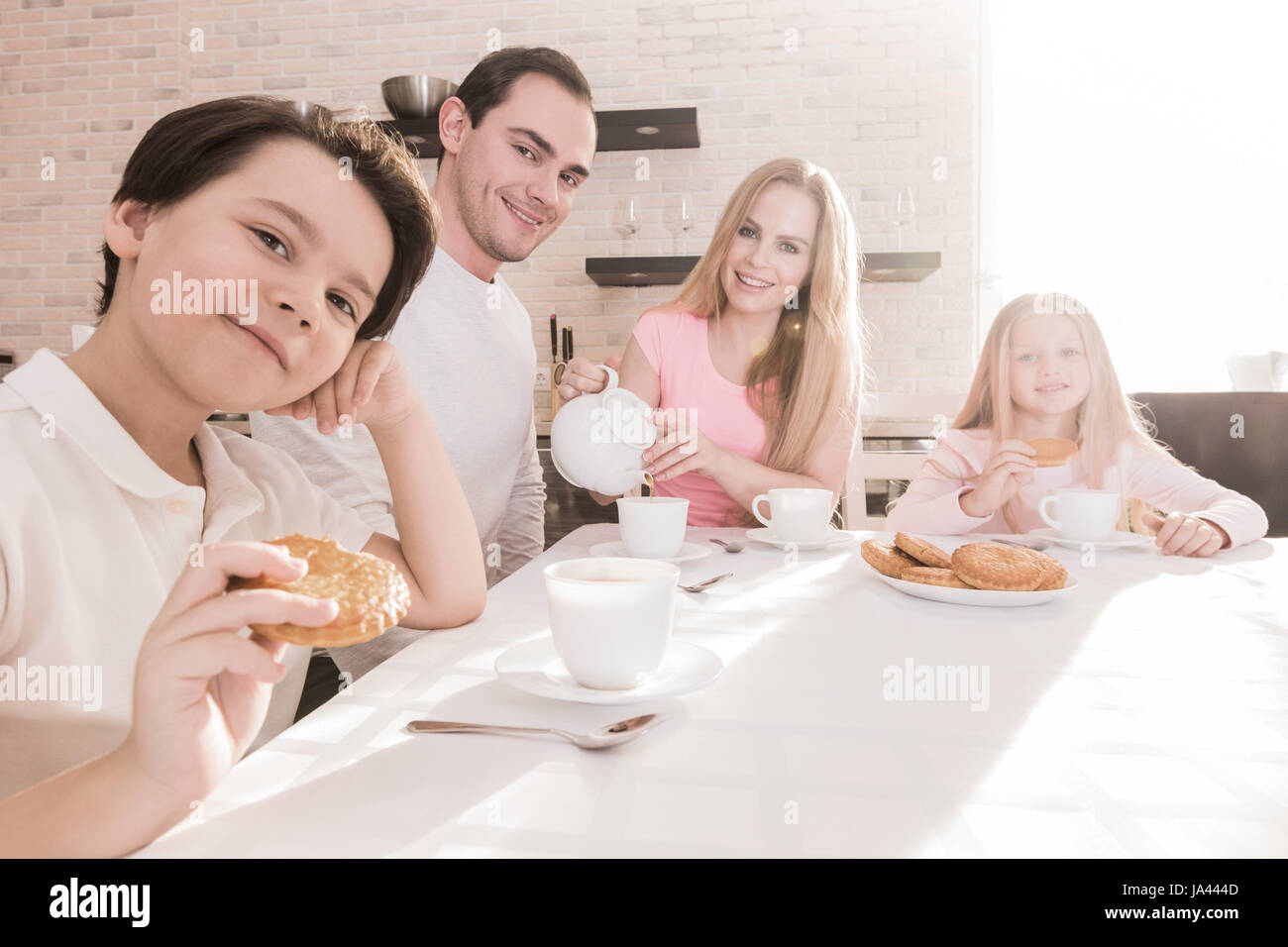 Happy family with children having breakfast at home Stock Photo