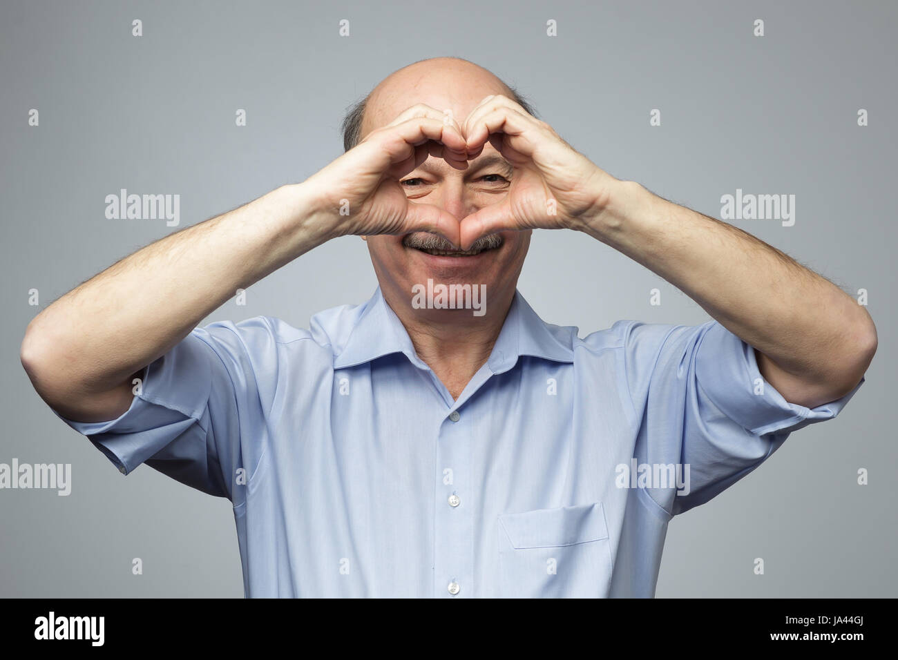 old man making out of hands heart. Doing charity work, take care of the health, or being in love Stock Photo