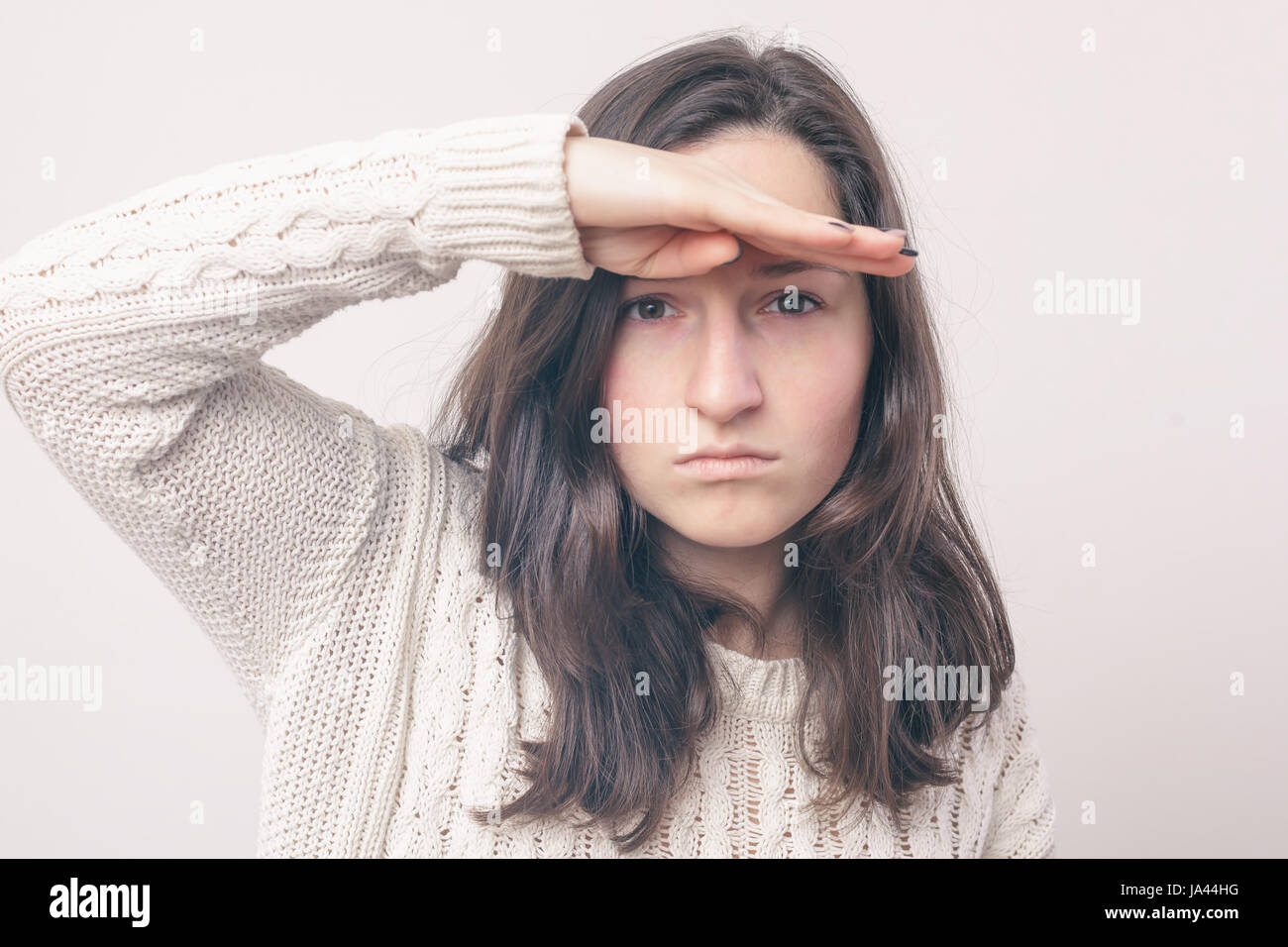 girl with long hair is looking for something, looking into the distance. She put a hand to her forehead Stock Photo