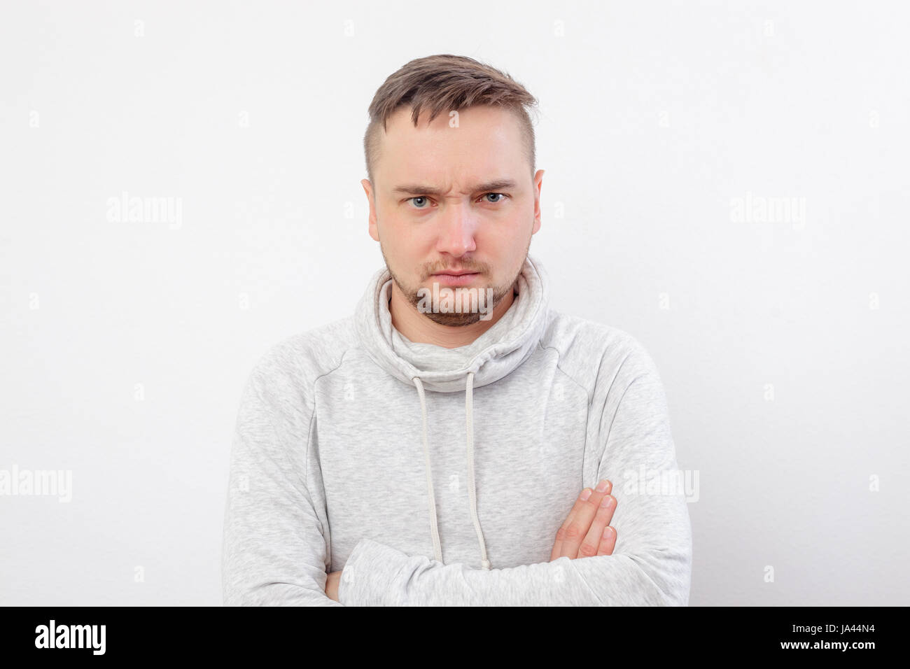Young man in hoodie angry brow knits Stock Photo