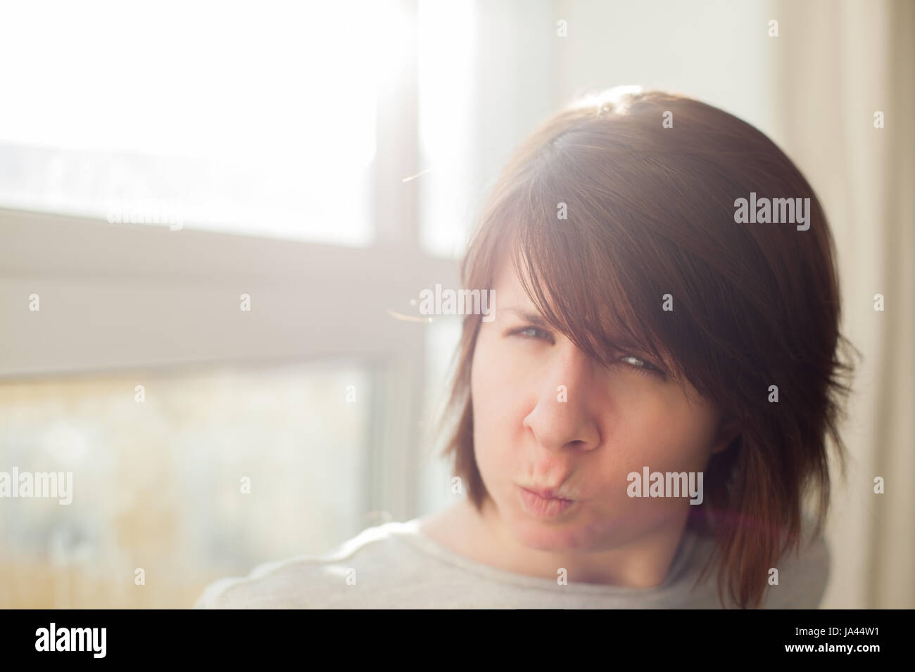 Angry girl frowns face and dissatisfied looks ahead Stock Photo