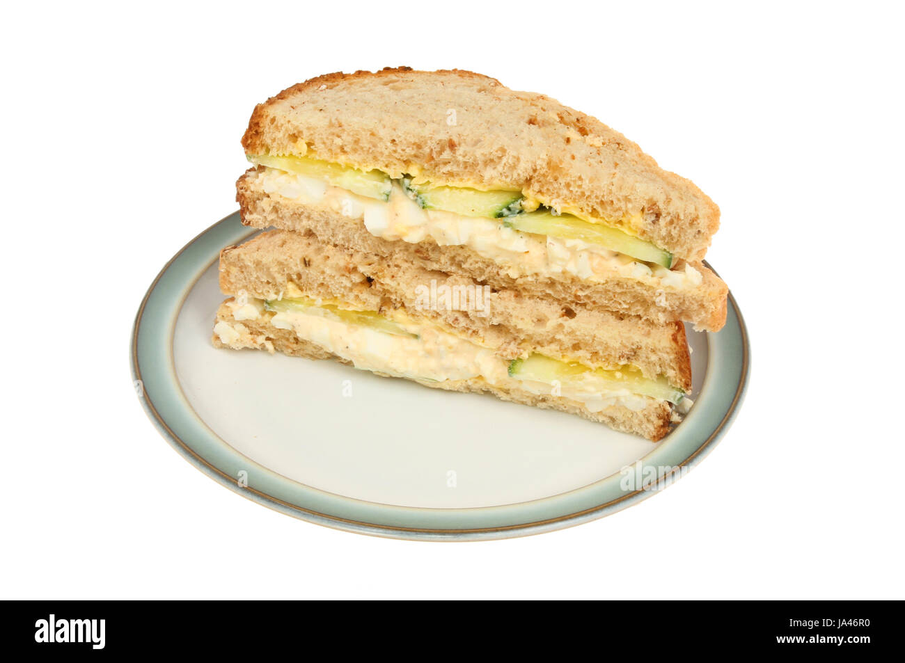 Egg mayonnaise and cucumber sandwich on a plate isolated against white
