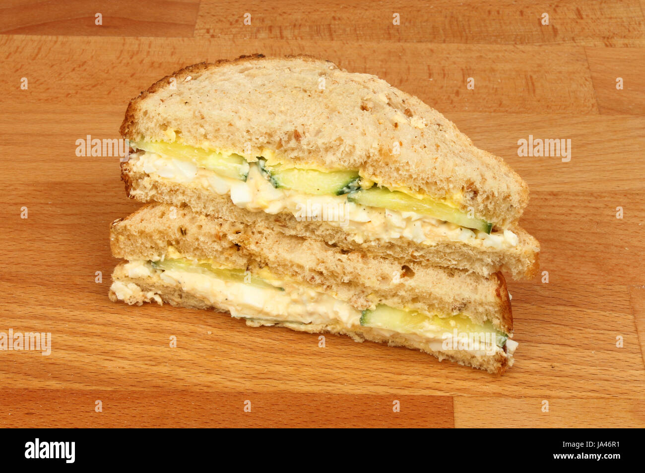 Egg mayonnaise and cucumber sandwiches on a wooden chopping board Stock