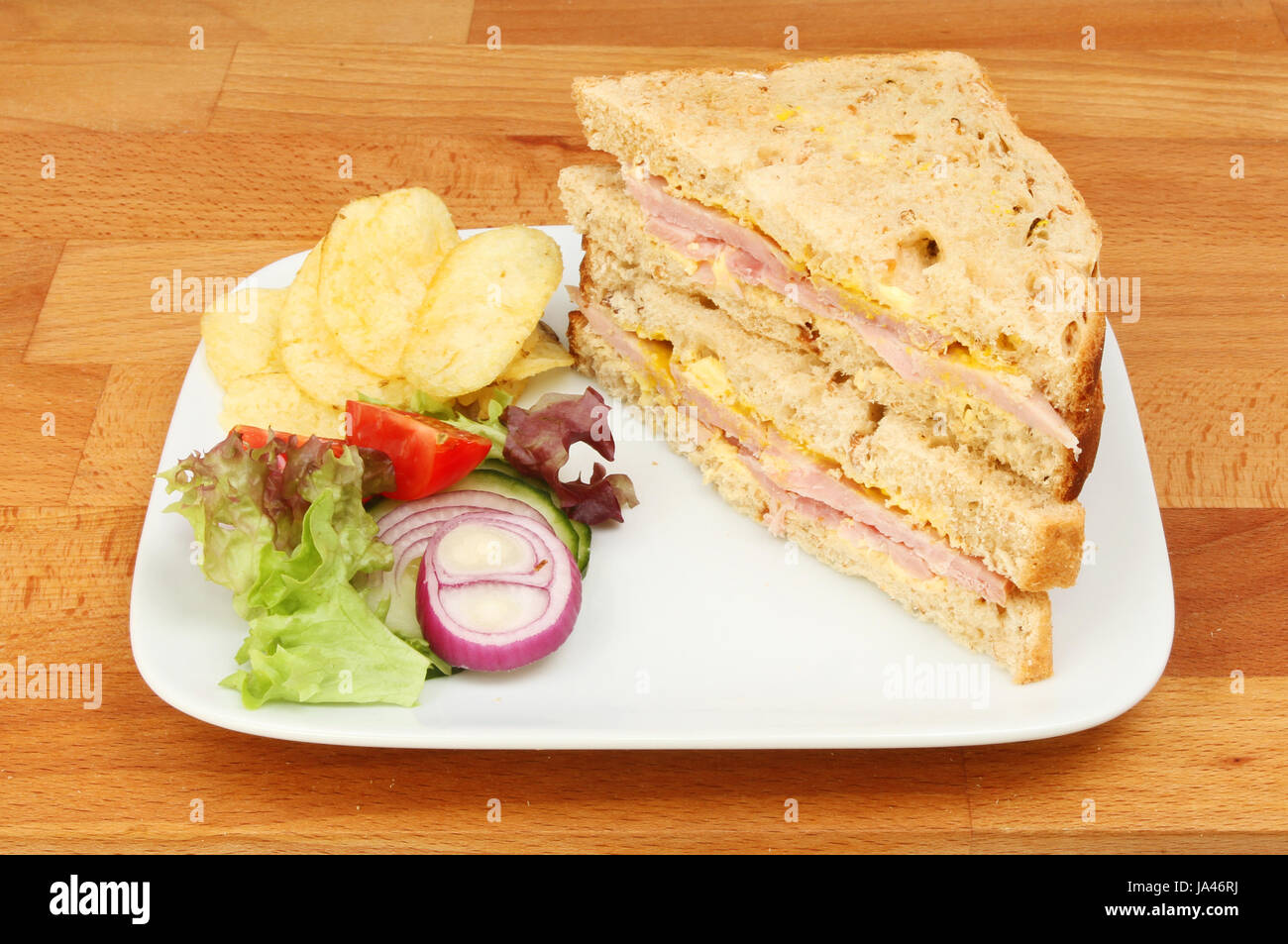 Ham And Mustard Sandwiches With Salad And Potato Crisps On A Plate On A Wooden Worktop Stock Photo Alamy