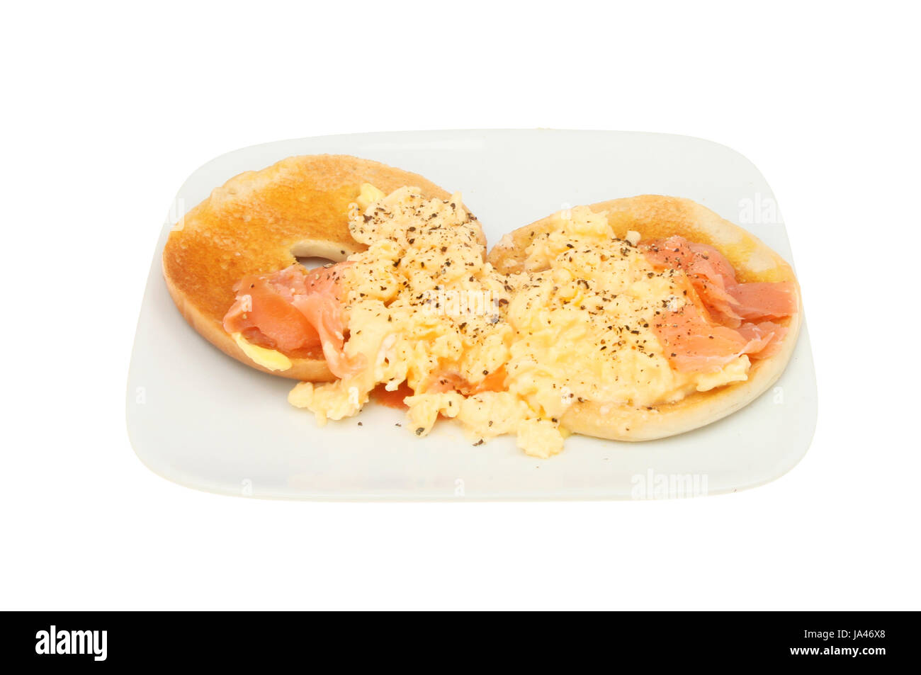 Smoked salmon and scrambled egg on a toasted bagel isolated against white Stock Photo