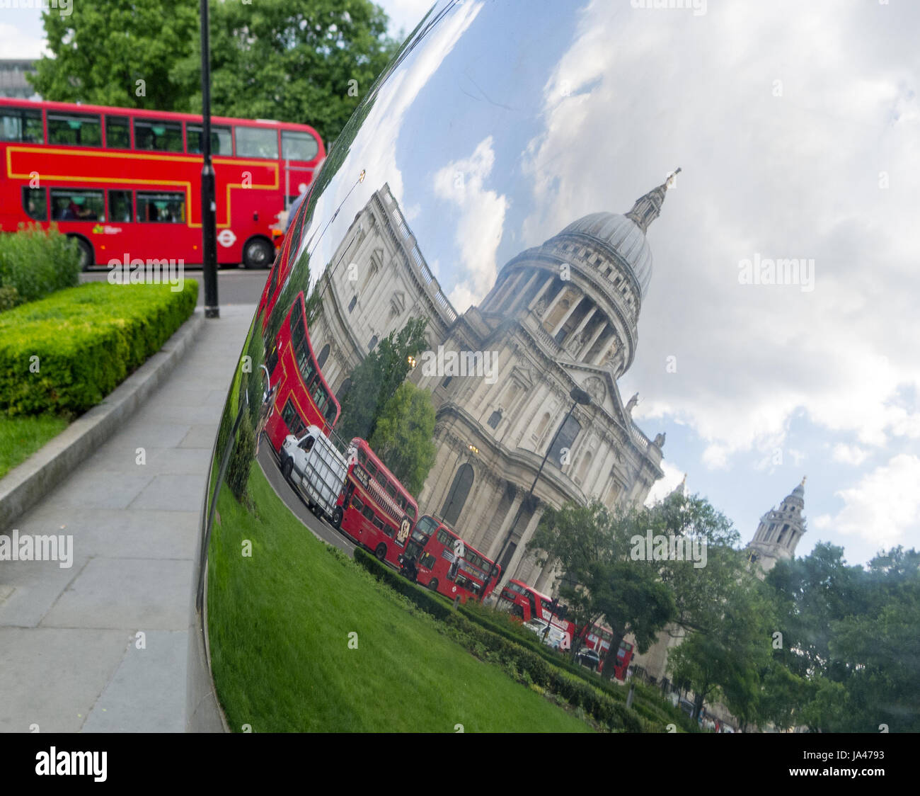 St Paul's Cathedral and London buses reflected in metal ball sculpture Stock Photo