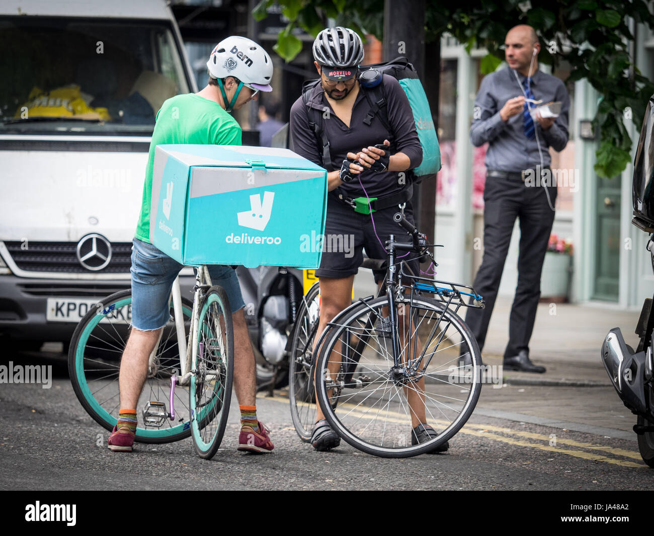 Deliveroo Bike Food Delivery Couriers chat and compare jobs in central London Stock Photo