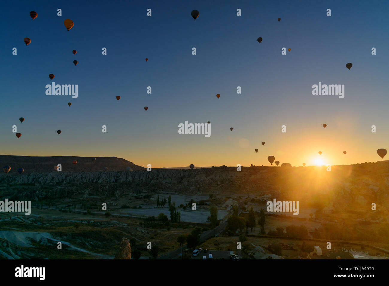 Hot air balloons flying over valley of Cappadocia at sunrise. Nevsehir ...