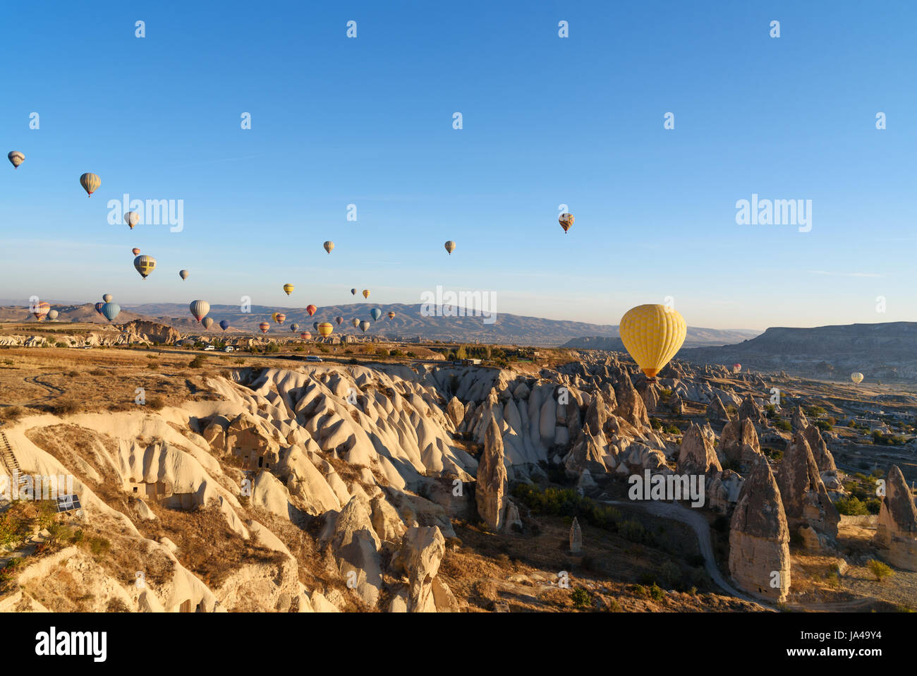 Hot air balloons flying over valley of Cappadocia in the morning ...