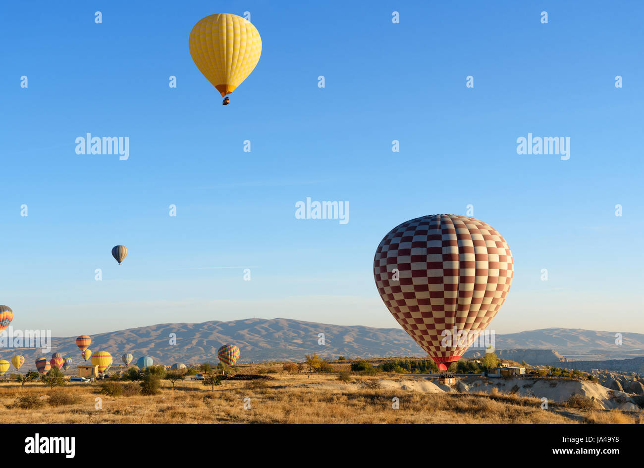 Hot air balloons landing after flight over valley of Cappadocia in the morning. Nevsehir Province. Turkey. Stock Photo