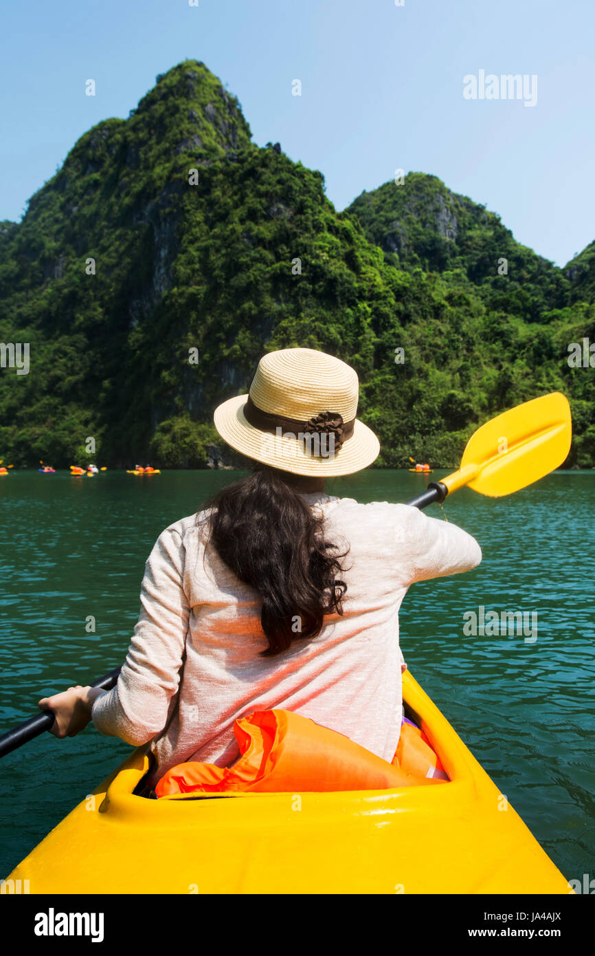 Girl kayaking on the seaside of Halong bay in Vietnam Stock Photo