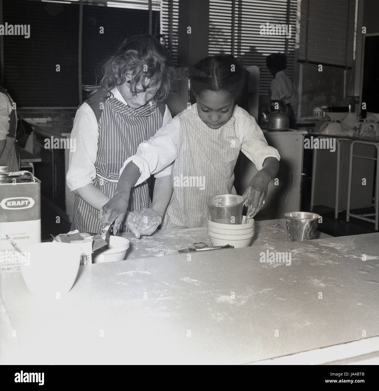 1960s, historical, two young girls in a cookery or home economics classroom at Sedgehill School, Lewisham, South London, England, UK, opened in 1957 and one of the first comprehensive schools in Britian. Stock Photo