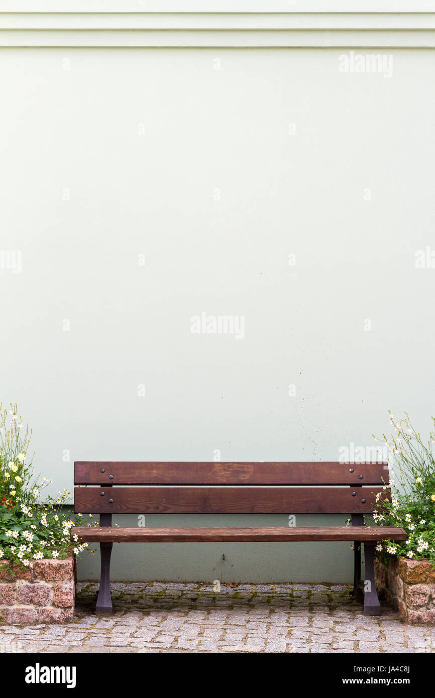 Wooden bench in front of wall and pots of flowers Stock Photo - Alamy