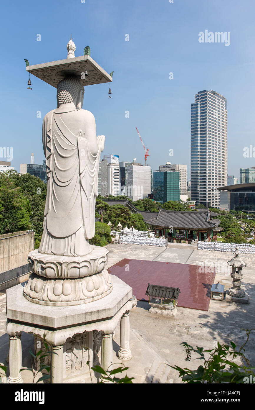 A Buddha statue at the Bongeunsa temple looks out over Seoul.  Old and modern in perfect harmony. Stock Photo