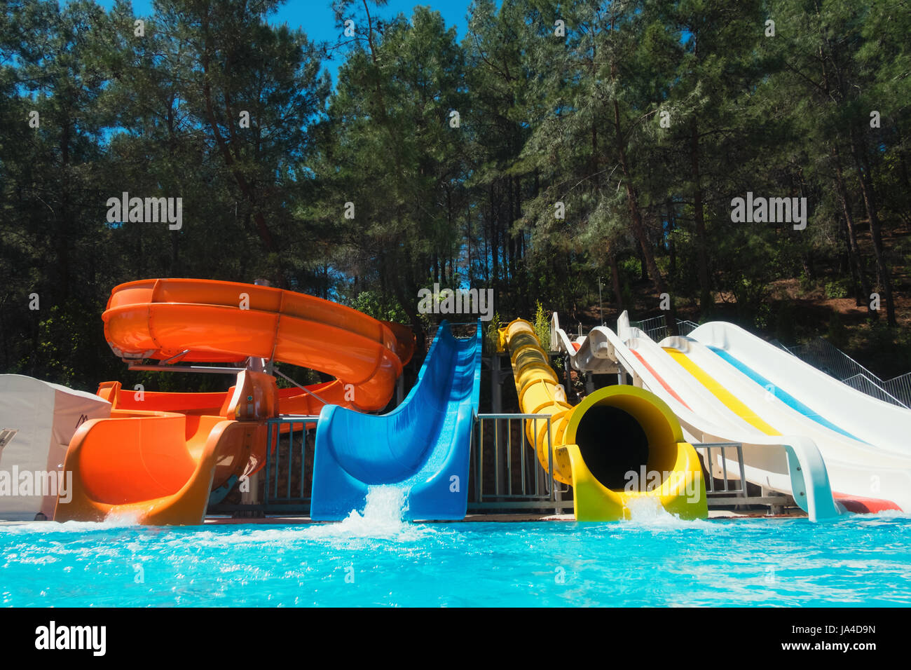 Colorful aquapark in green forest. Summer attraction in sea resort Stock Photo