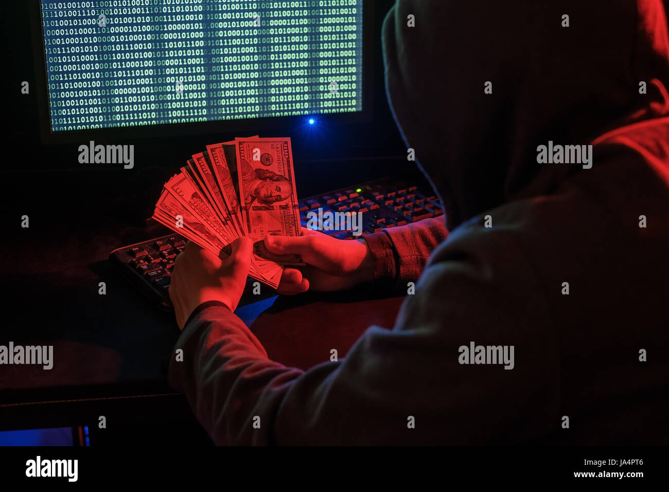 Cyber criminal calculates revenue from extortion or a virus program. Stock Photo