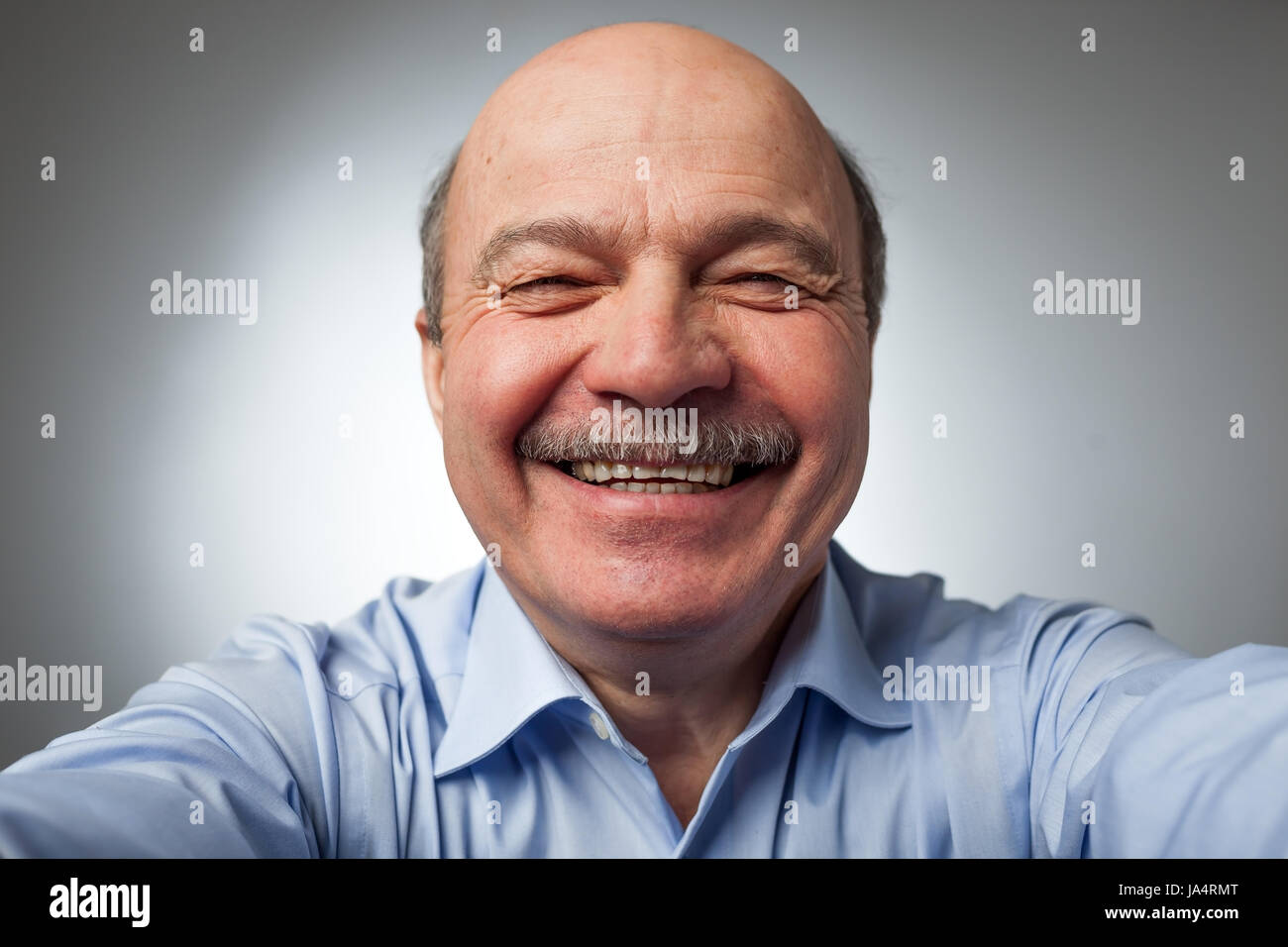 Elderly man laughs from ear to ear, giggles on the funny stories. Be happy of news or events Stock Photo