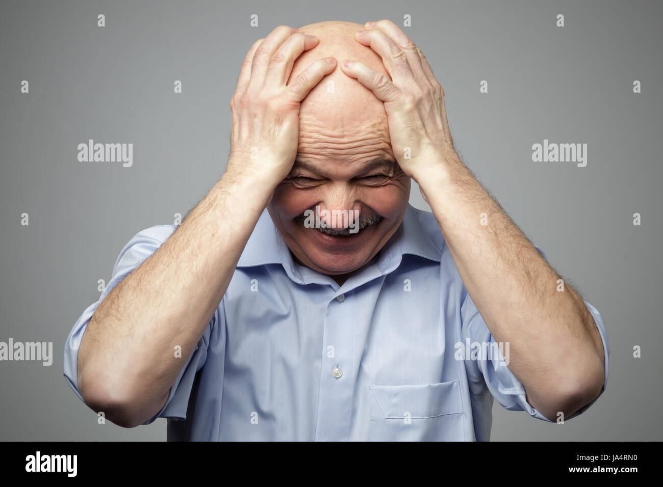 Elderly man in despair grabs his head. Problems with money, at work, in the family Stock Photo