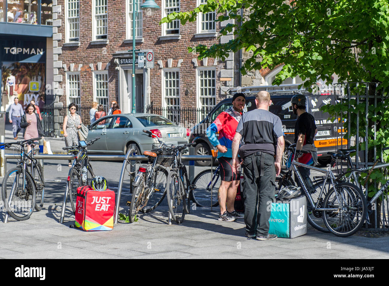 Food delivery riders for Deliveroo and Just Eat take a break in Cork, Ireland. Stock Photo