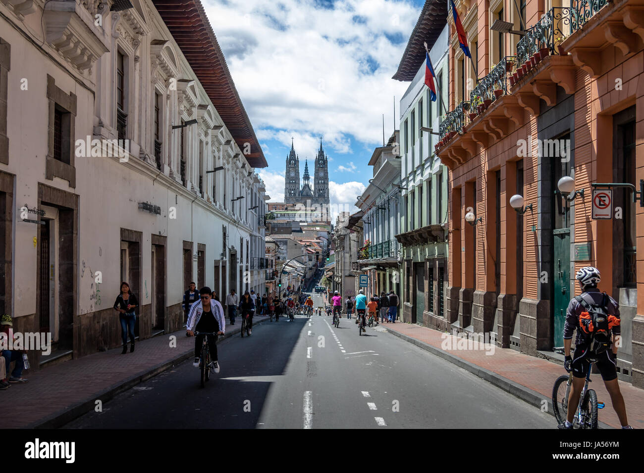 Bikers and pedestrians on a sunday closed street of Quito and Basilica del Voto Nacional - Quito, Ecuador Stock Photo