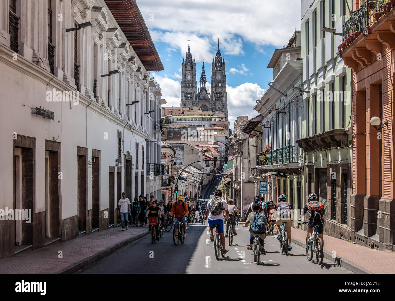 Bikers and pedestrians on a sunday closed street of Quito and Basilica del Voto Nacional - Quito, Ecuador Stock Photo