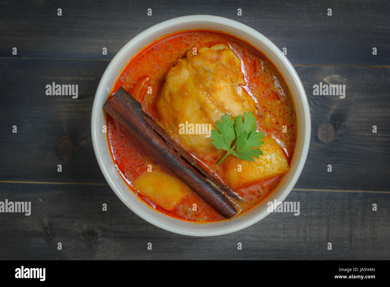 Chicken massaman curry on wooden background on top view, Thai local food Stock Photo