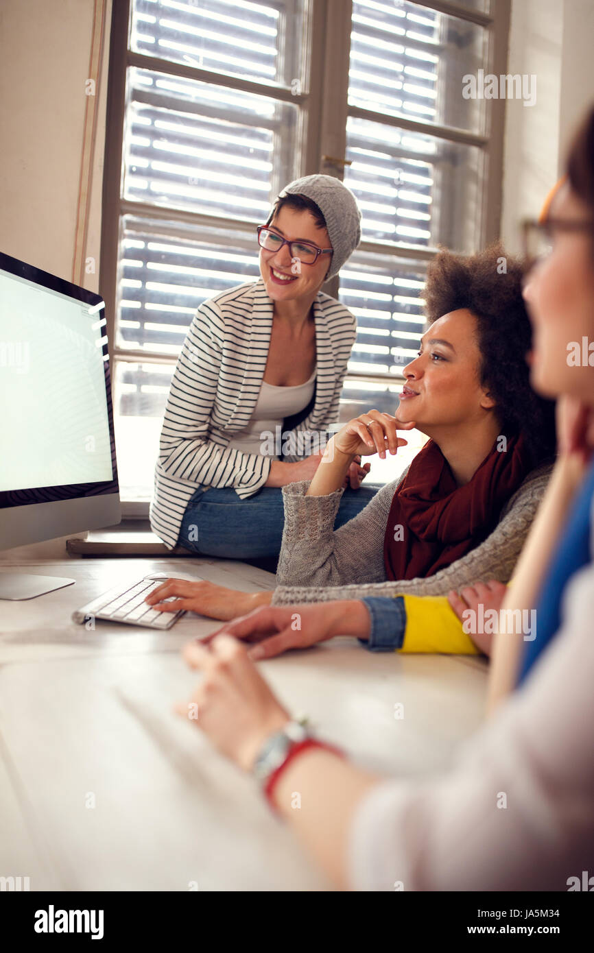 Happy women working together on computer in office Stock Photo
