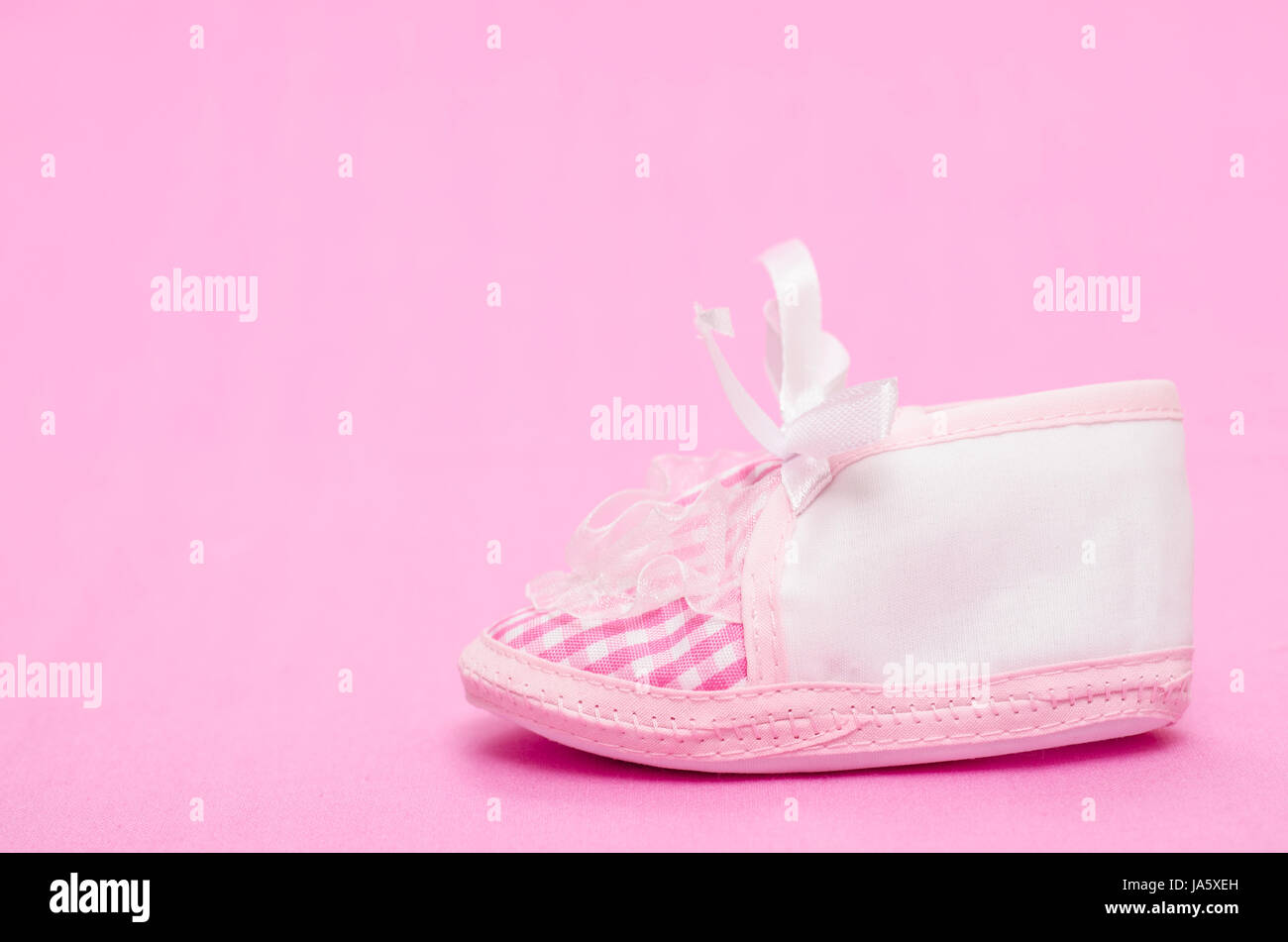 female baby shoes on pink background Stock Photo