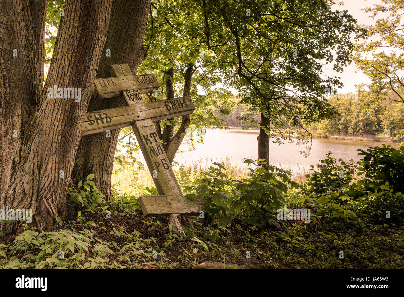 Old wooden russian Philippians cross in a cemetery or graveyard, churchyard in Wojnowo. Polish Masuria, many cultures and nations remains. Stock Photo