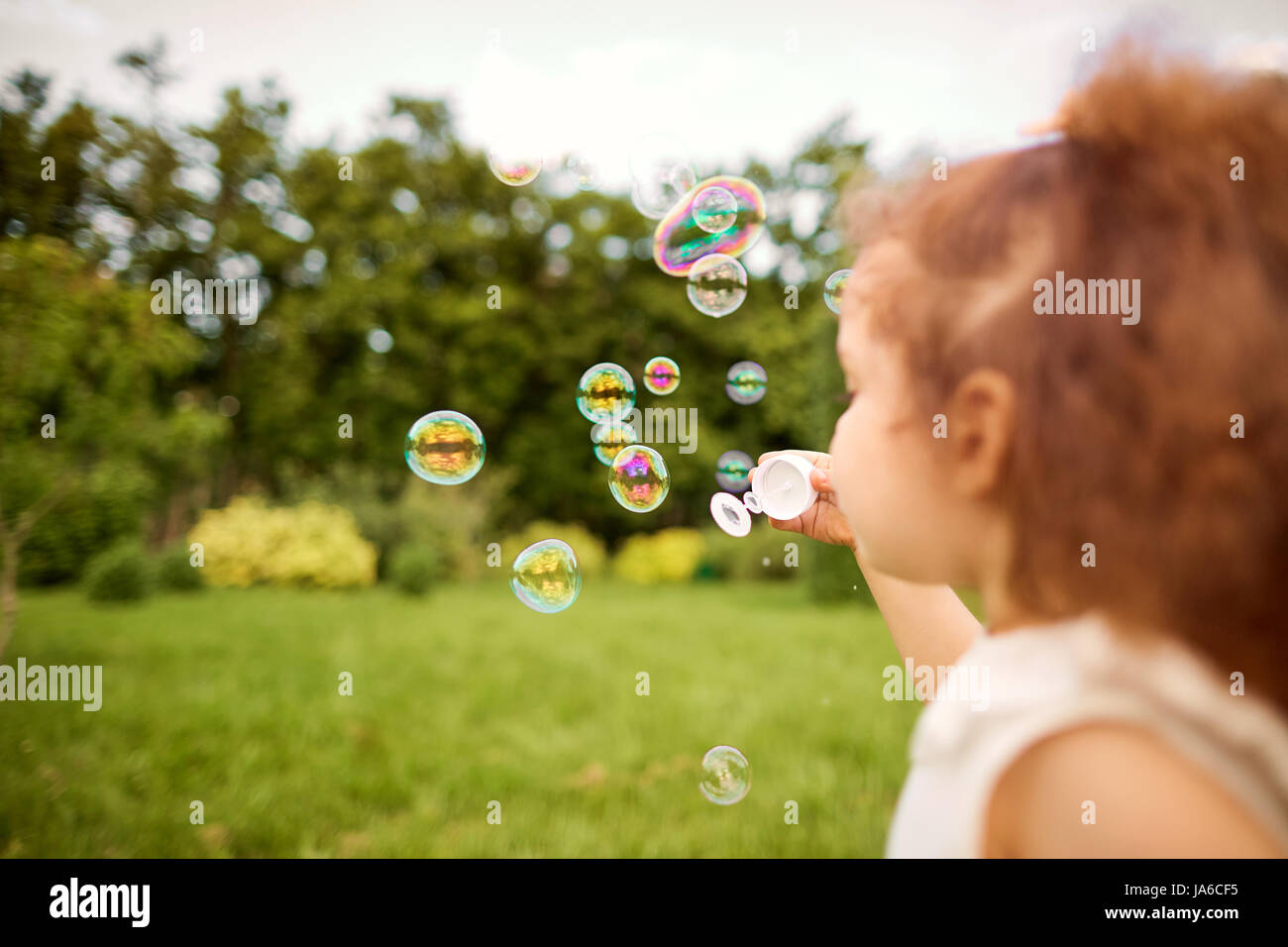 Child is playing with soap bubbles in the park Stock Photo - Alamy