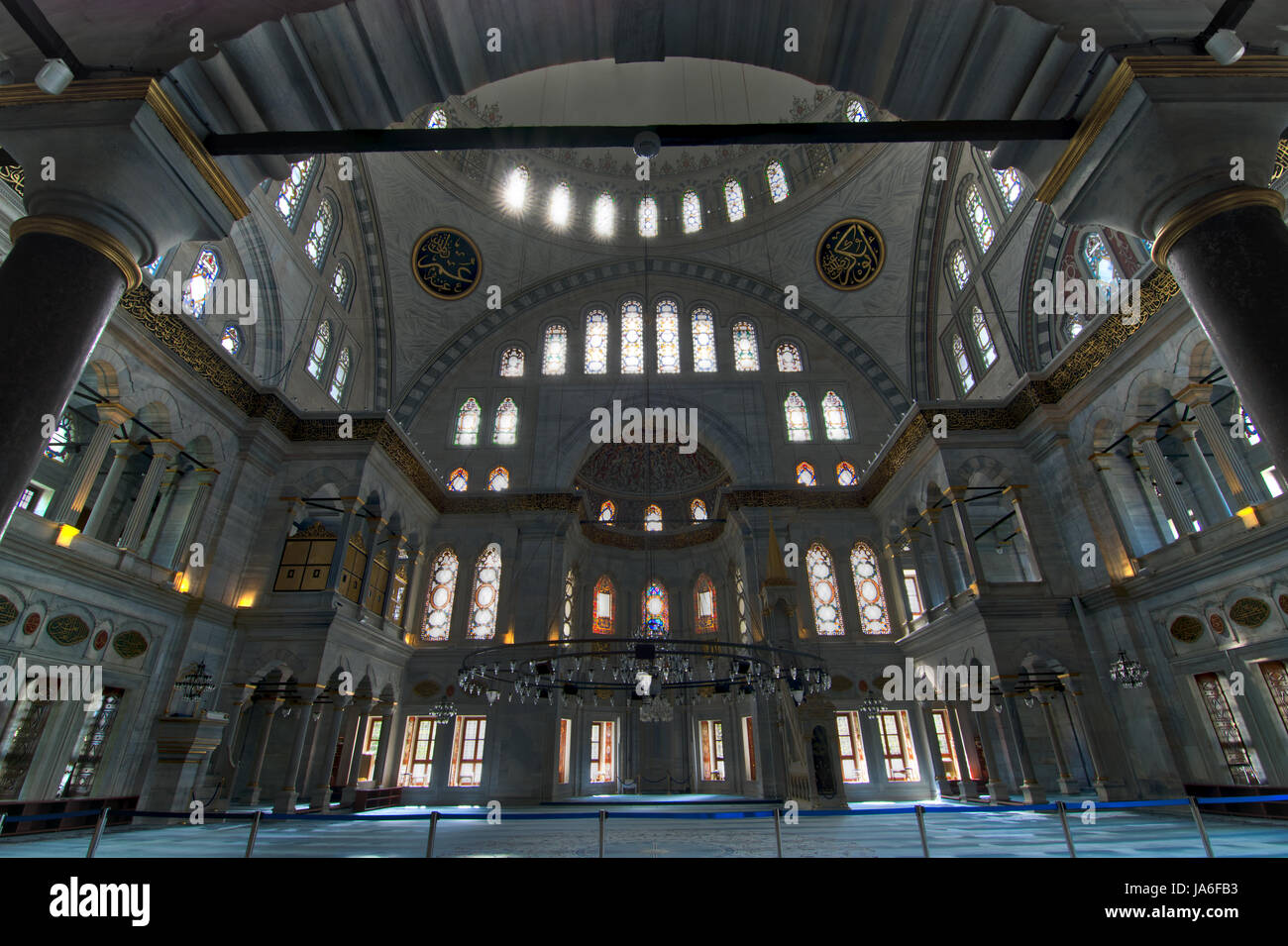 Interior of Nuruosmaniye Mosque, Istanbul, Turkey, with huge arches, decorated domes and colored stained glass windows Stock Photo