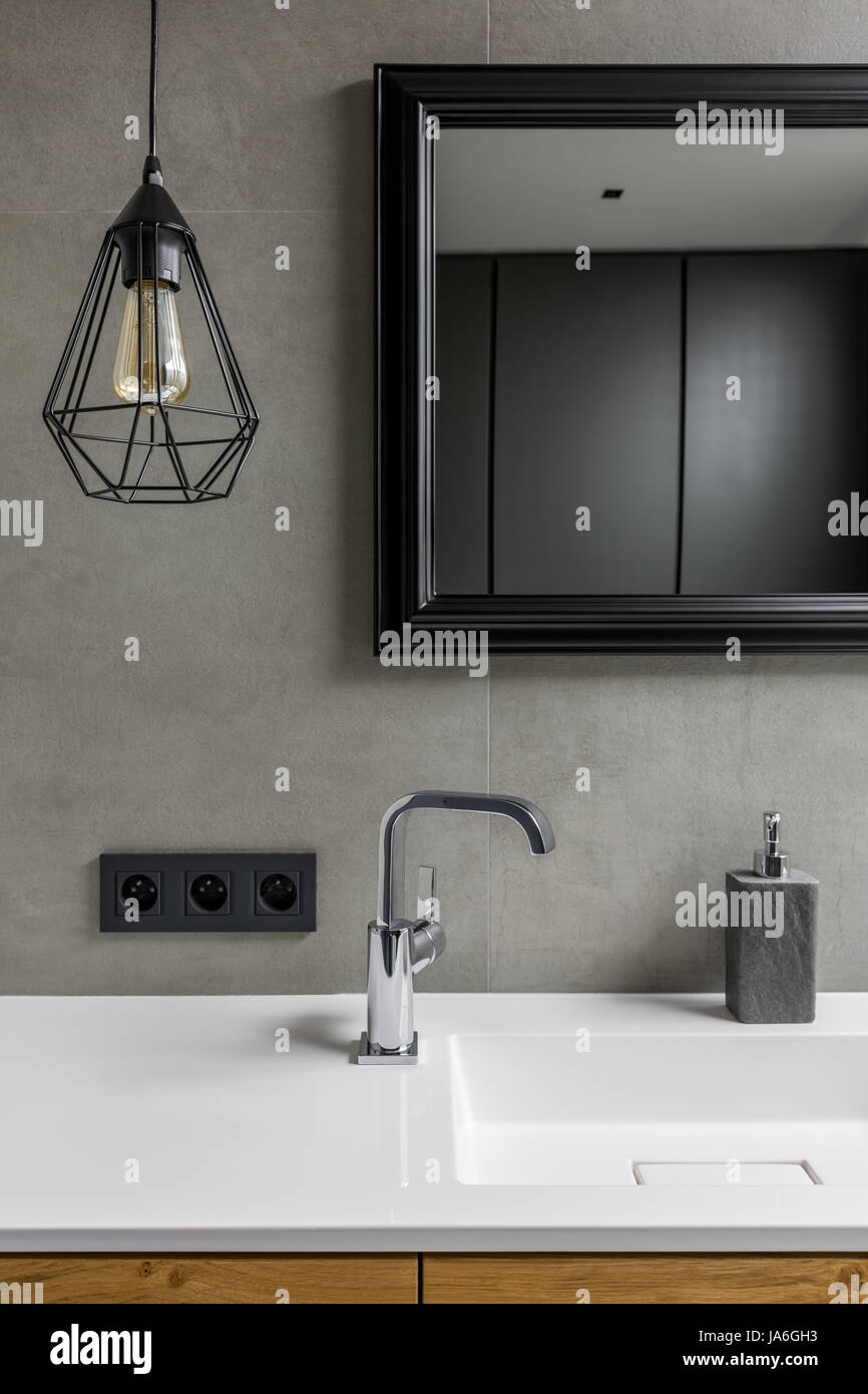 Gray bathroom with black ceiling lamp mirror in black frame and