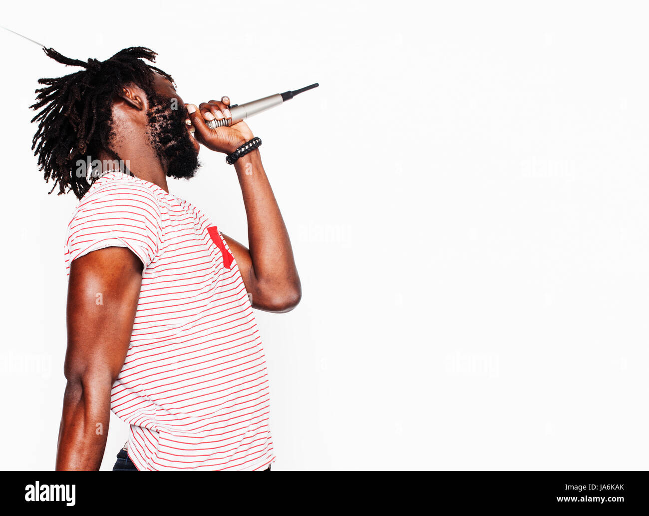 young handsome african american boy singing emotional with microphone isolated on white background, in motion gesturing smiling, lifestyle people concept  Stock Photo