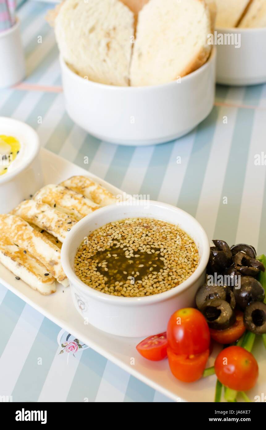 A very healthy Lebanese breakfast with bread, zaatar spread, hallumi cheese, olives and tomatoes. Very typical dish of lebanon and Mediterranean cuisine. Stock Photo
