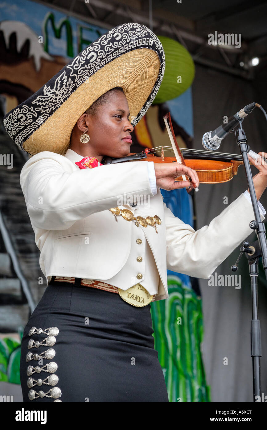 Live music. Female mariachi violinist, dark skinned young woman musician, wearing a Mexican mariachi sombrero, dressed with traditional Mexican mariachi clothing. Stock Photo