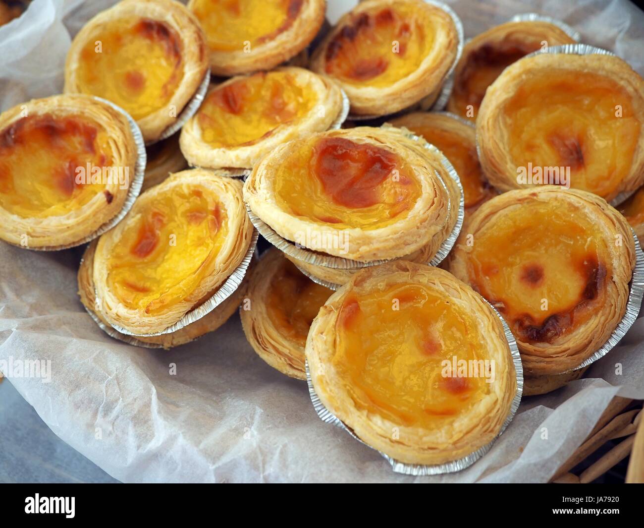 Traditional homemade egg tart fresh and fragrant, tasty warm, crusty, bakery in a white wooden box, street food Stock Photo