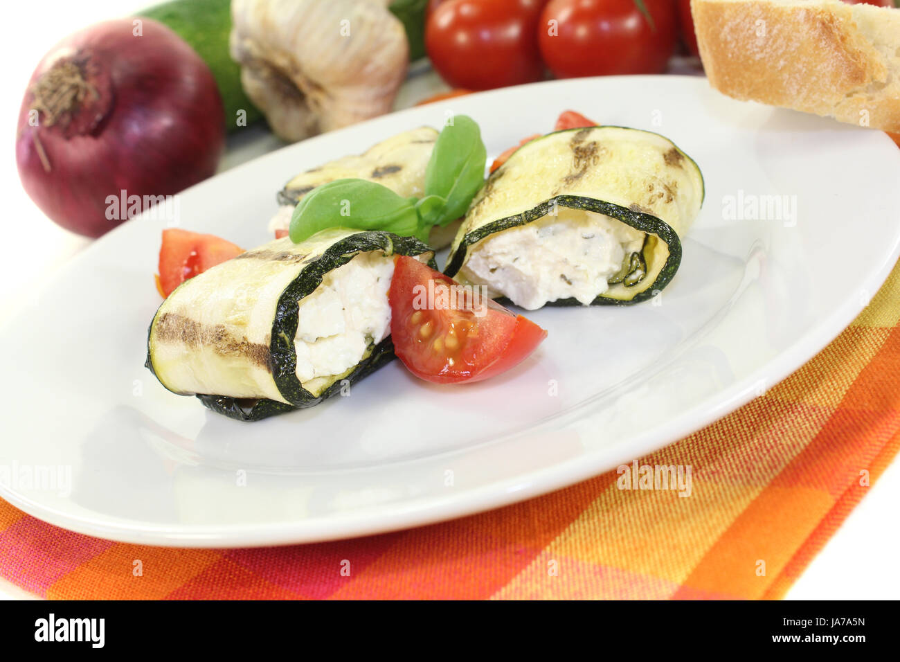 delicious stuffed zucchini rolls with cream cheese on a light background Stock Photo