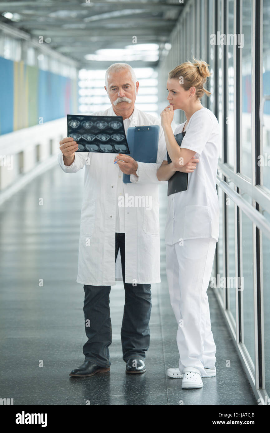 medics looking at x-ray scan at hospitals corridor Stock Photo
