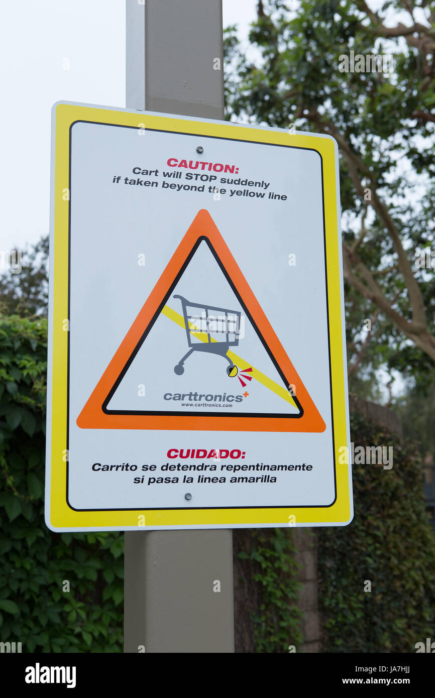 Caution carts will stop suddenly sign. Carttronics a developer of electronic systems used to stop the loss of shopping carts at retail stores, Stock Photo